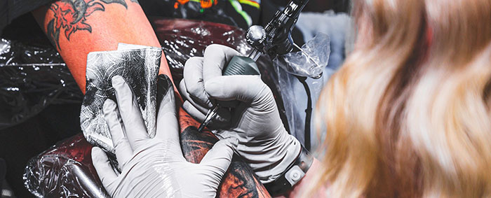 Tatuadora trabajando en una pieza de Ruby Rose