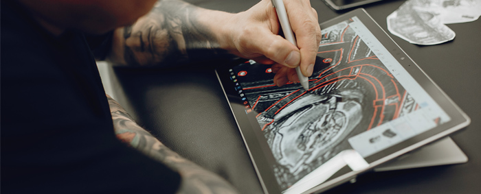 Hombre tatuado diseñando en la tablet
