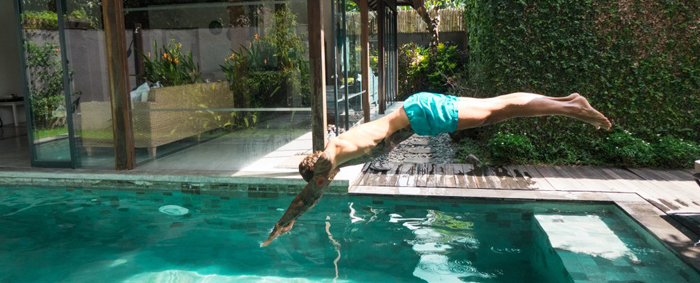 Homme tatoué plongeant dans une piscine