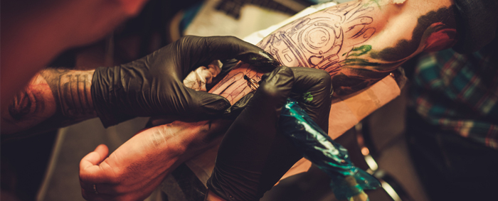 Tattoo artist working on a forearm tattoo
