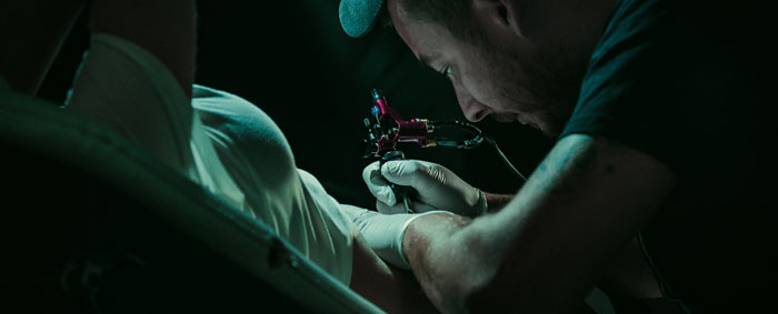 Tatuador tatuando a un cliente