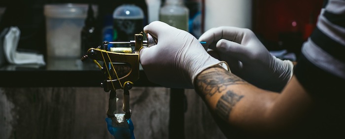 Tattoo artist setting up a tattoo machine