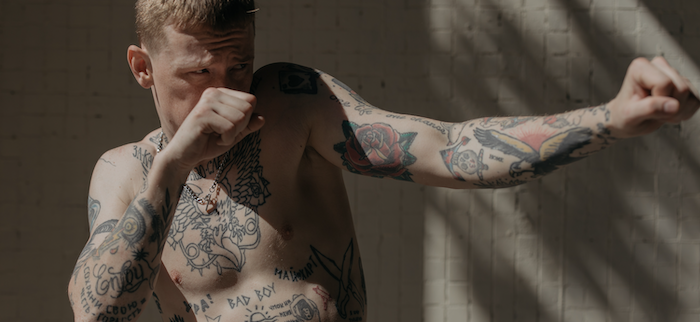Tattooed man shadow boxing.